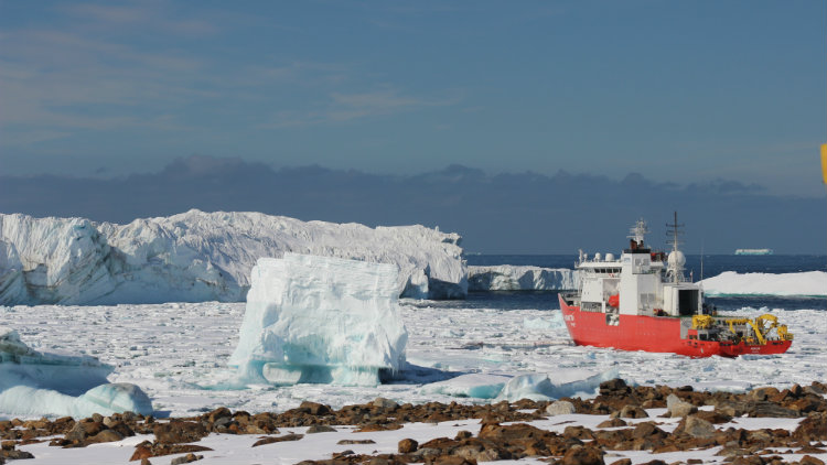 A boat sails amidst a sea of ice.